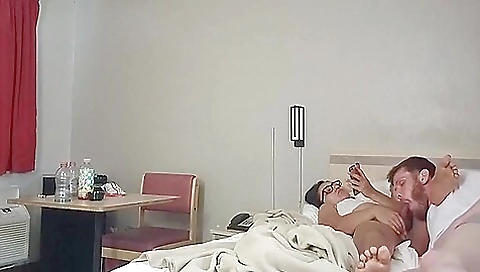 A brunette is peeping at her boyfriend on the couch